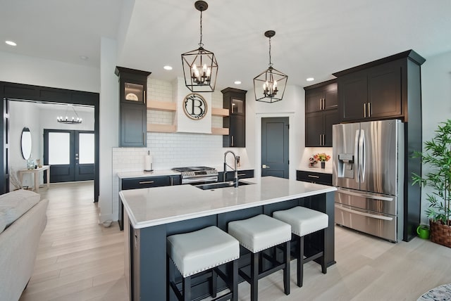 2216 Timberview Dr, Norwalk, IA 50211 - kitchen with appliances with stainless steel finishes, a sink, a chandelier, decorative backsplash, and recessed lighting