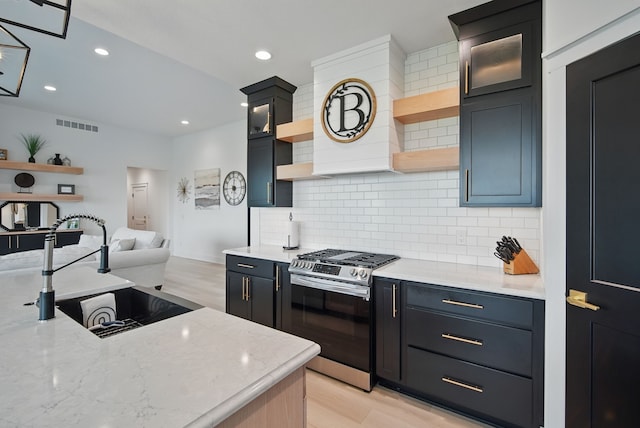 2216 Timberview Dr, Norwalk, IA 50211 - kitchen with open shelves, stainless steel gas range, open floor plan, a sink, and decorative backsplash