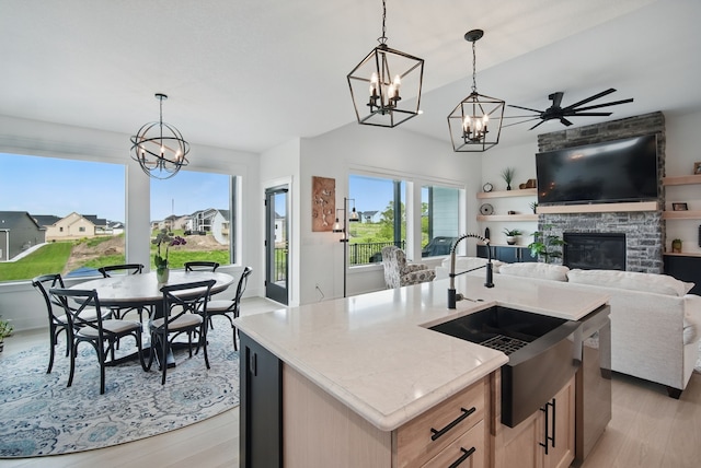 2216 Timberview Dr, Norwalk, IA 50211 - kitchen featuring a chandelier, open floor plan, a sink, light wood-style flooring, and lofted ceiling