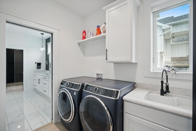 2216 Timberview Dr, Norwalk, IA 50211 - laundry area featuring cabinet space, washer and dryer, and light marble finish floors