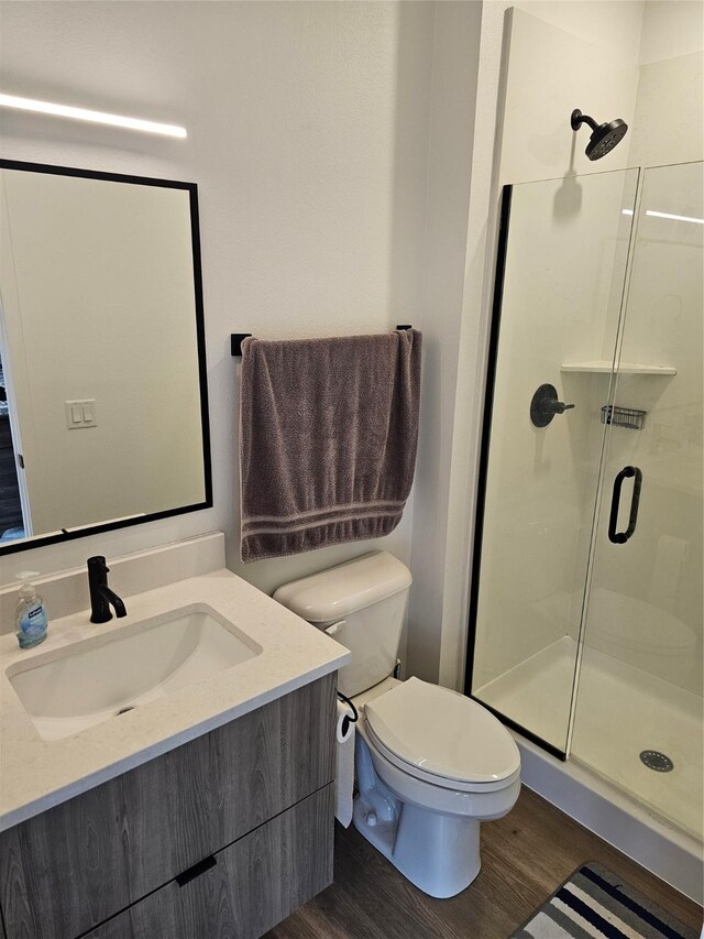 924 12th St, Des Moines, IA 50309 - full bathroom featuring a stall shower, wood finished floors, toilet, and vanity
