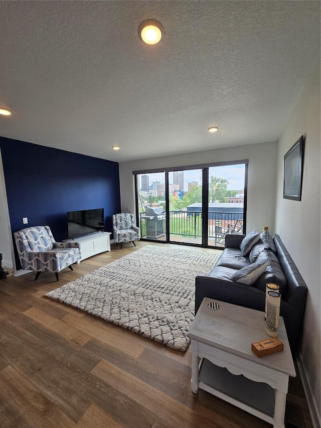 924 12th St, Des Moines, IA 50309 - living area featuring a textured ceiling, wood finished floors, recessed lighting, and baseboards