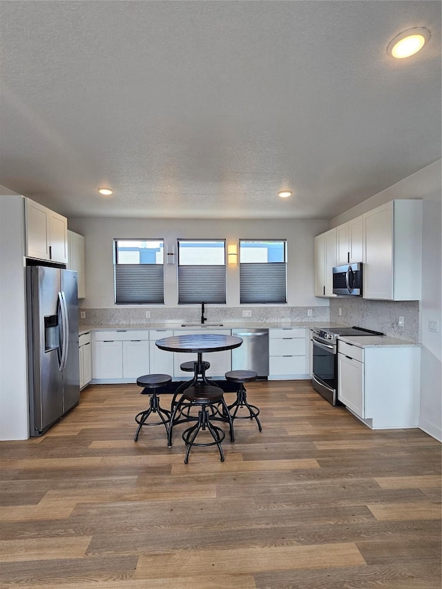 924 12th St, Des Moines, IA 50309 - kitchen with appliances with stainless steel finishes, light countertops, a sink, backsplash, and plenty of natural light