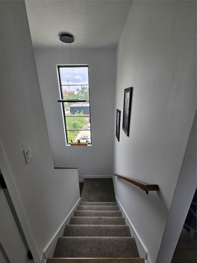 924 12th St, Des Moines, IA 50309 - stairs with baseboards, a textured wall, and a textured ceiling