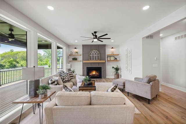 9814 Watermeadow Cir, Johnston, IA 50131 - living area featuring a ceiling fan, recessed lighting, light wood-style flooring, and a fireplace