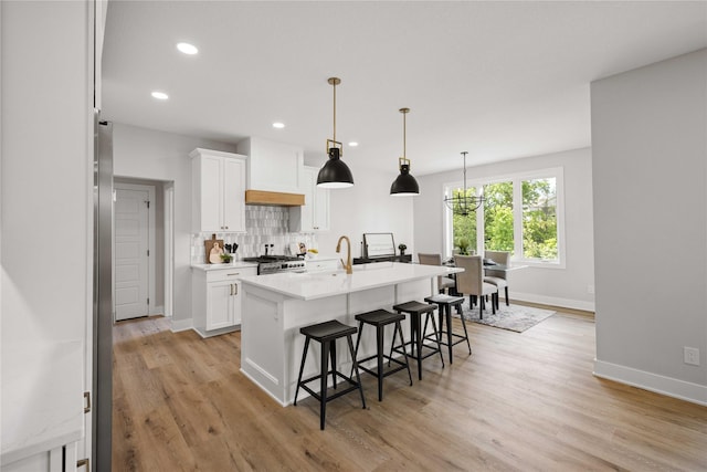 9814 Watermeadow Cir, Johnston, IA 50131 - kitchen with high end stainless steel range, baseboards, a breakfast bar, white cabinetry, and recessed lighting