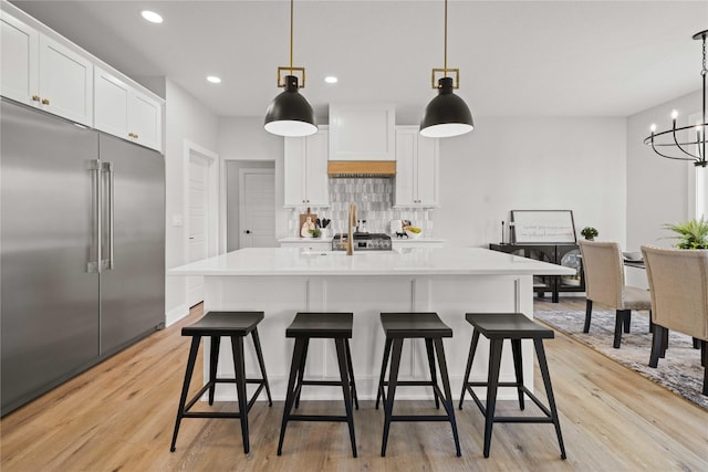 9814 Watermeadow Cir, Johnston, IA 50131 - kitchen featuring high quality fridge, decorative backsplash, custom range hood, light wood-type flooring, and light countertops