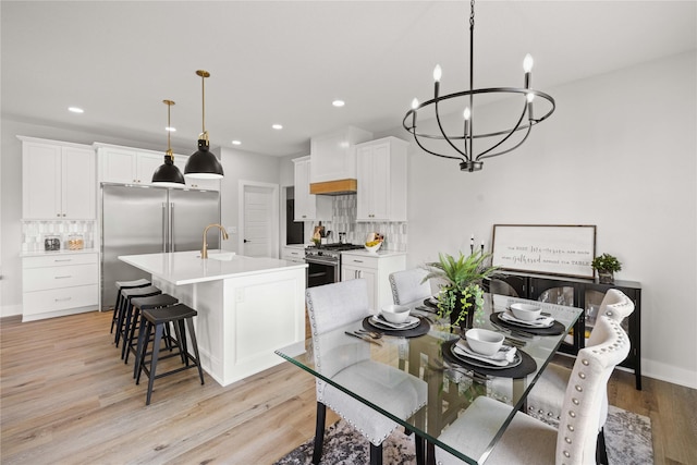 9814 Watermeadow Cir, Johnston, IA 50131 - dining area with a chandelier, light wood-style floors, recessed lighting, and baseboards