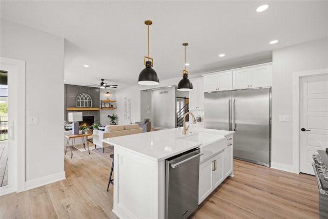 9814 Watermeadow Cir, Johnston, IA 50131 - kitchen with appliances with stainless steel finishes, a sink, white cabinetry, light wood-style floors, and recessed lighting