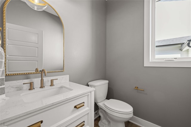 9814 Watermeadow Cir, Johnston, IA 50131 - bathroom with vanity, toilet, baseboards, and wood finished floors
