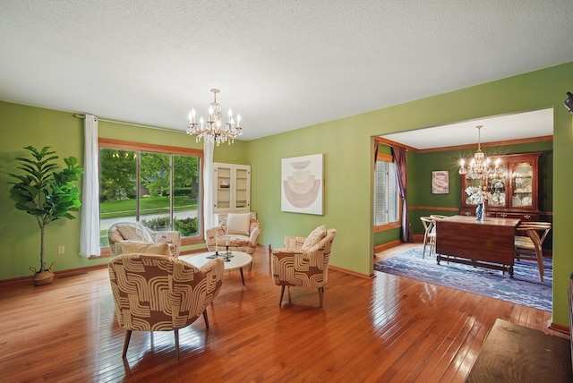 711 36th St, West Des Moines, IA 50265 - living room featuring a chandelier, hardwood / wood-style floors, baseboards, and a textured ceiling