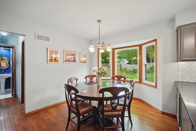 711 36th St, West Des Moines, IA 50265 - dining area with hardwood / wood-style flooring, a chandelier, and baseboards
