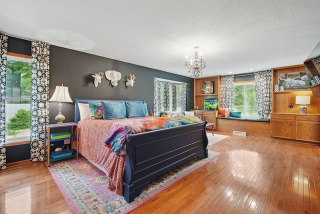 711 36th St, West Des Moines, IA 50265 - bedroom with a chandelier and light wood-style flooring
