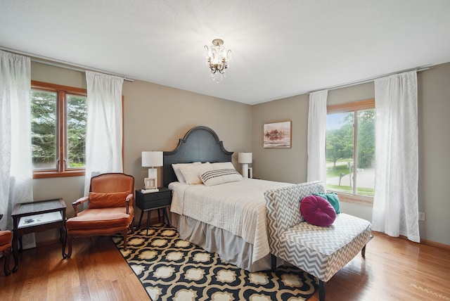 711 36th St, West Des Moines, IA 50265 - bedroom featuring wood finished floors and a chandelier