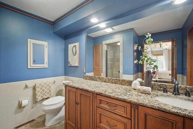 711 36th St, West Des Moines, IA 50265 - bathroom featuring ornamental molding, toilet, vanity, a wainscoted wall, and a shower
