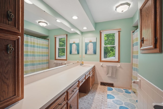 711 36th St, West Des Moines, IA 50265 - bathroom featuring tile walls, plenty of natural light, wainscoting, vanity, and recessed lighting