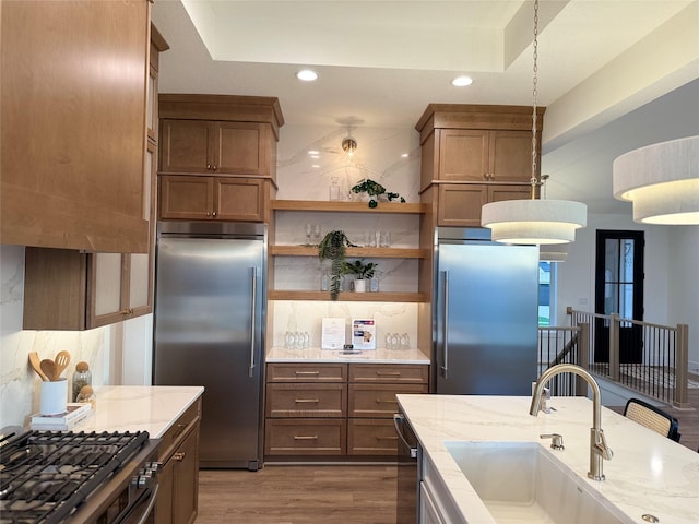 18109 Tanglewood Dr, Clive, IA 50325 - kitchen with appliances with stainless steel finishes, a sink, dark wood finished floors, light stone counters, and recessed lighting