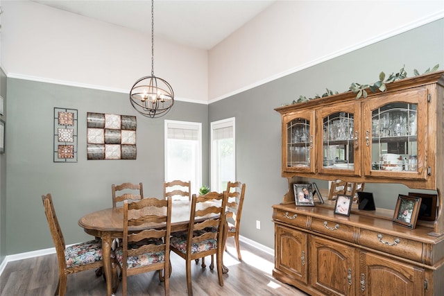 6640 Monticello Ct, Johnston, IA 50131 - dining room with light wood-style flooring, a chandelier, baseboards, and a high ceiling