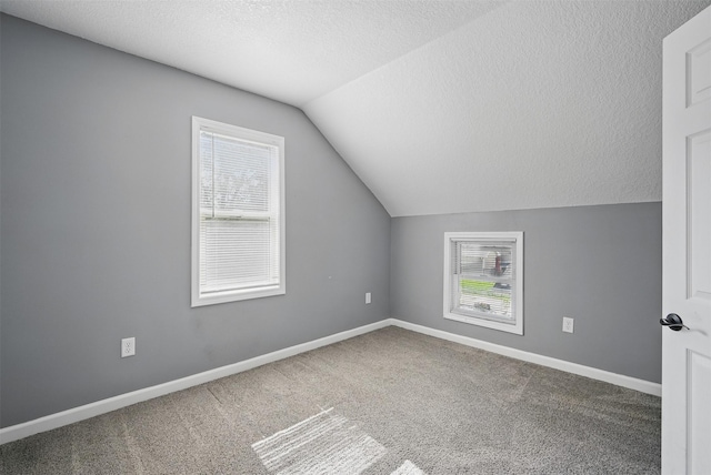 3421 Amherst St, Des Moines, IA 50313 - additional living space with lofted ceiling, carpet floors, a textured ceiling, and baseboards