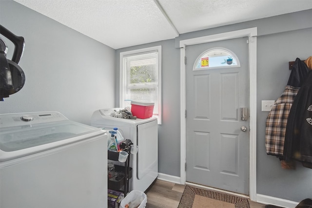 3421 Amherst St, Des Moines, IA 50313 - laundry room featuring washing machine and clothes dryer, wood finished floors, baseboards, and a textured ceiling
