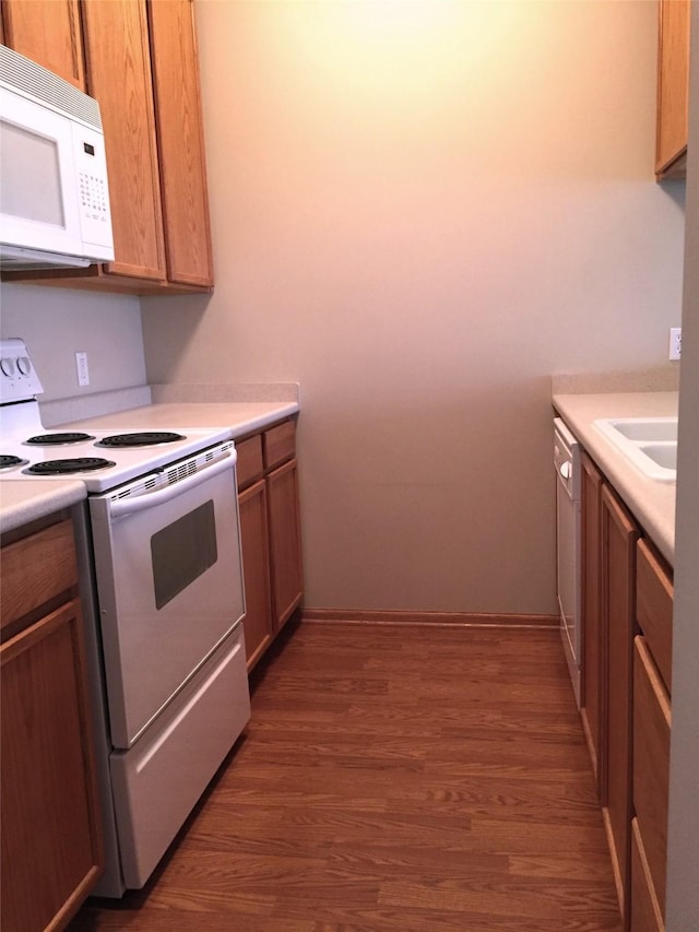 1740 SE La Grant Pkwy Unit 18, Waukee, IA 50263 - kitchen featuring white appliances, dark wood-style floors, light countertops, and a sink
