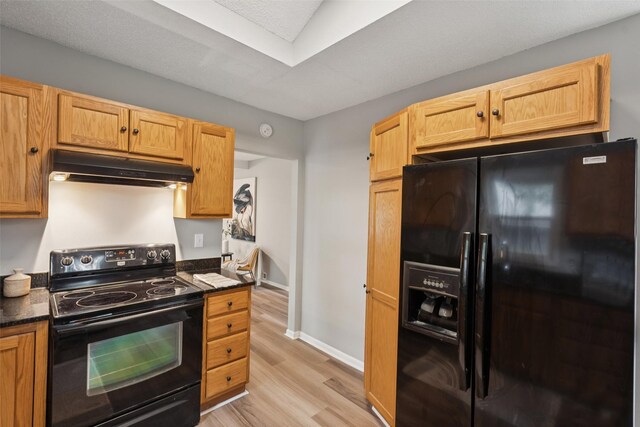 827 40th Pl, Des Moines, IA 50312 - kitchen featuring black appliances, under cabinet range hood, dark countertops, and light wood-type flooring