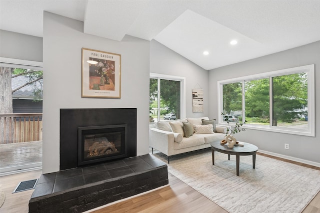 827 40th Pl, Des Moines, IA 50312 - living area featuring wood finished floors, a glass covered fireplace, lofted ceiling, and recessed lighting