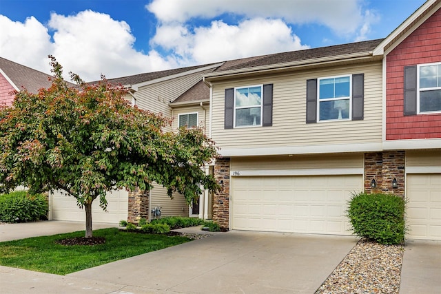 196 79th St, West Des Moines, IA 50266 - view of property with stone siding, driveway, and an attached garage