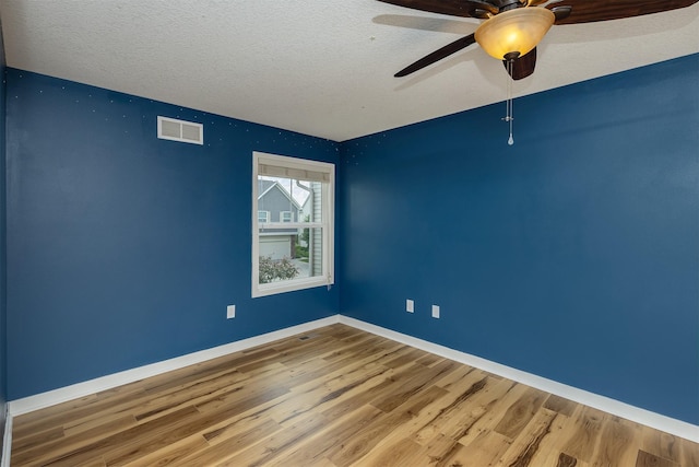 196 79th St, West Des Moines, IA 50266 - empty room with wood finished floors, baseboards, a ceiling fan, and a textured ceiling