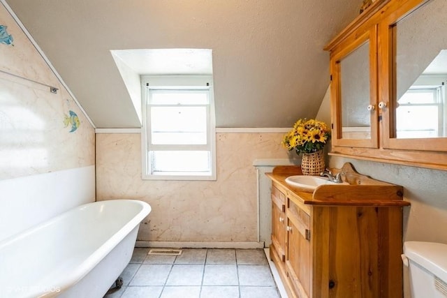 2638 Capitol Ave, Des Moines, IA 50317 - bathroom with a soaking tub, vanity, lofted ceiling, toilet, and tile patterned flooring