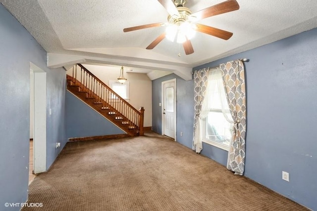 2638 Capitol Ave, Des Moines, IA 50317 - unfurnished living room with stairs, carpet flooring, ceiling fan, lofted ceiling, and a textured ceiling