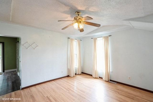 2638 Capitol Ave, Des Moines, IA 50317 - unfurnished room featuring a ceiling fan, wood finished floors, vaulted ceiling, a textured ceiling, and baseboards