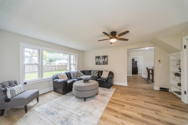212 Nile Kinnick Dr N, Adel, IA 50003 - living area featuring light wood finished floors, a ceiling fan, and baseboards