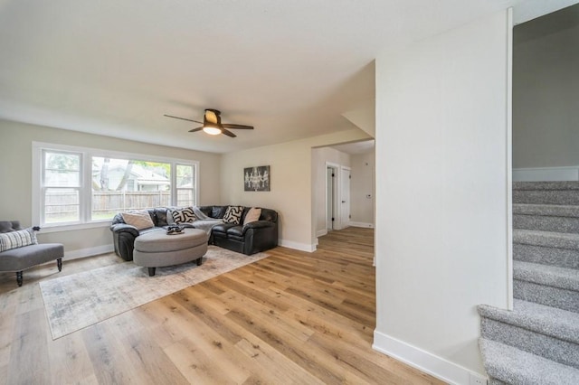 212 Nile Kinnick Dr N, Adel, IA 50003 - living area featuring stairs, baseboards, ceiling fan, and light wood-style floors