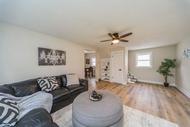 212 Nile Kinnick Dr N, Adel, IA 50003 - living area featuring ceiling fan, light wood-style flooring, baseboards, and stairs