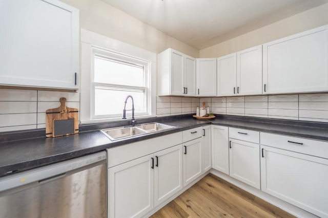 212 Nile Kinnick Dr N, Adel, IA 50003 - kitchen featuring stainless steel dishwasher, a sink, dark countertops, light wood finished floors, and white cabinets