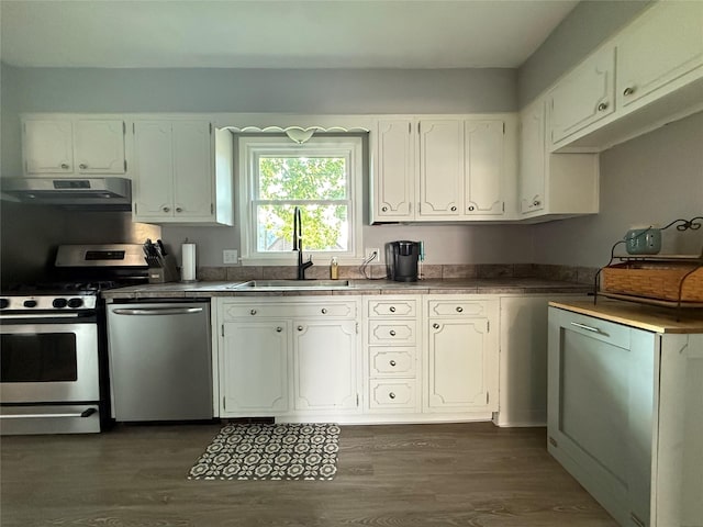 1541 42nd St, Des Moines, IA 50311 - kitchen with appliances with stainless steel finishes, exhaust hood, dark wood-style floors, and white cabinets