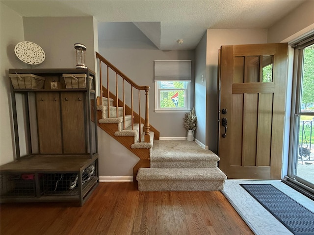 1541 42nd St, Des Moines, IA 50311 - entrance foyer featuring wood finished floors, stairs, and a textured ceiling