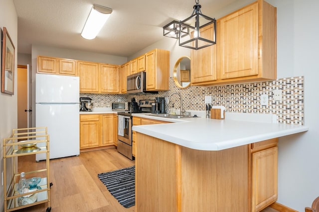 5221 Village Run Ave Unit 402, Des Moines, IA 50317 - kitchen featuring appliances with stainless steel finishes, light brown cabinets, a sink, and light wood-type flooring
