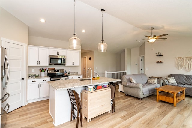 513 Walnut Dr, Huxley, IA 50124 - kitchen with stainless steel appliances, open floor plan, lofted ceiling, white cabinets, and a ceiling fan