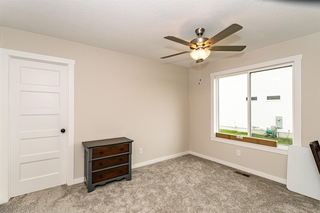 513 Walnut Dr, Huxley, IA 50124 - unfurnished room featuring a ceiling fan, light carpet, baseboards, and a textured ceiling
