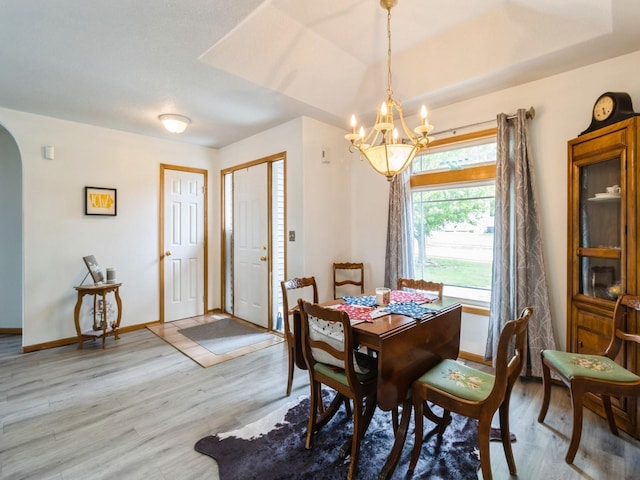 5213 SE 30th St, Des Moines, IA 50320 - dining space featuring arched walkways, a chandelier, light wood finished floors, and baseboards