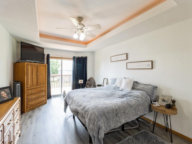 5213 SE 30th St, Des Moines, IA 50320 - bedroom with a tray ceiling, access to outside, light wood-type flooring, baseboards, and a ceiling fan