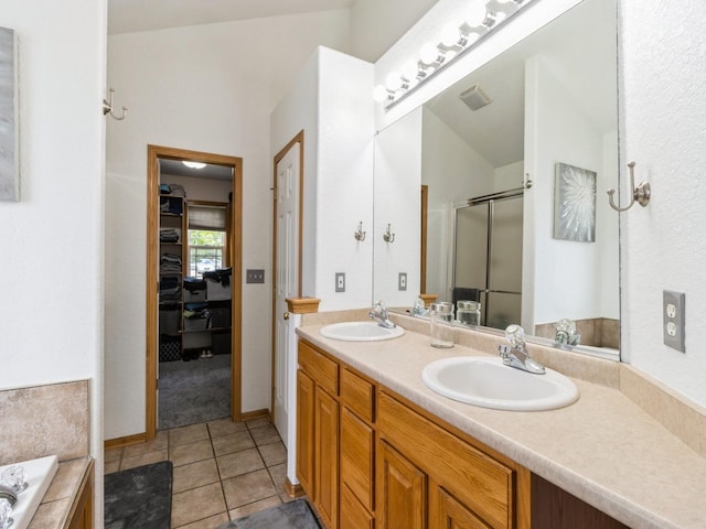 5213 SE 30th St, Des Moines, IA 50320 - bathroom featuring a stall shower, double vanity, tile patterned floors, a garden tub, and a spacious closet