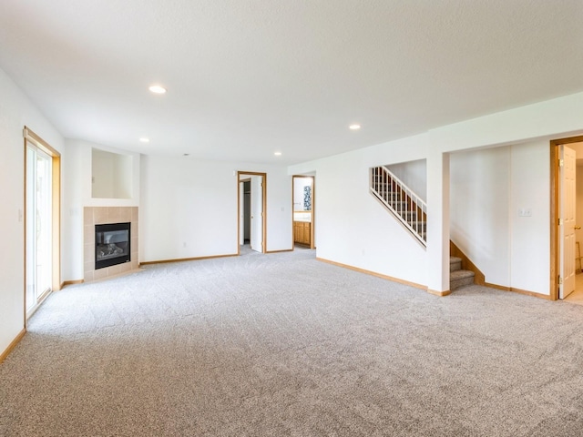 5213 SE 30th St, Des Moines, IA 50320 - unfurnished living room featuring light colored carpet, stairs, baseboards, recessed lighting, and a tiled fireplace