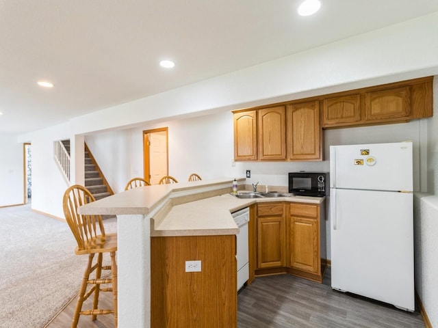 5213 SE 30th St, Des Moines, IA 50320 - kitchen featuring white appliances, a peninsula, a breakfast bar area, light countertops, and recessed lighting