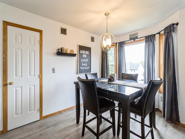5213 SE 30th St, Des Moines, IA 50320 - dining room featuring a chandelier, light wood finished floors, and baseboards