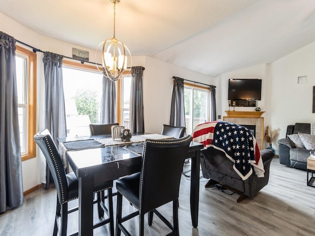 5213 SE 30th St, Des Moines, IA 50320 - dining area featuring a chandelier, lofted ceiling, wood finished floors, and a tiled fireplace