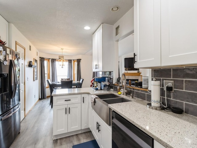 5213 SE 30th St, Des Moines, IA 50320 - kitchen featuring black dishwasher, stainless steel refrigerator with ice dispenser, white cabinets, and a textured ceiling