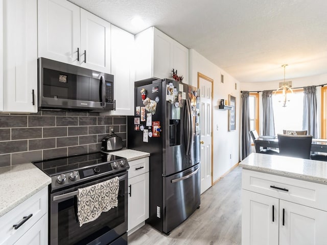 5213 SE 30th St, Des Moines, IA 50320 - kitchen featuring appliances with stainless steel finishes, backsplash, light wood-style floors, white cabinetry, and light stone counters